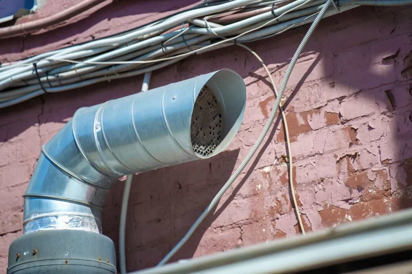 A sheet metal air duct run and elbow feeding a ventilation system