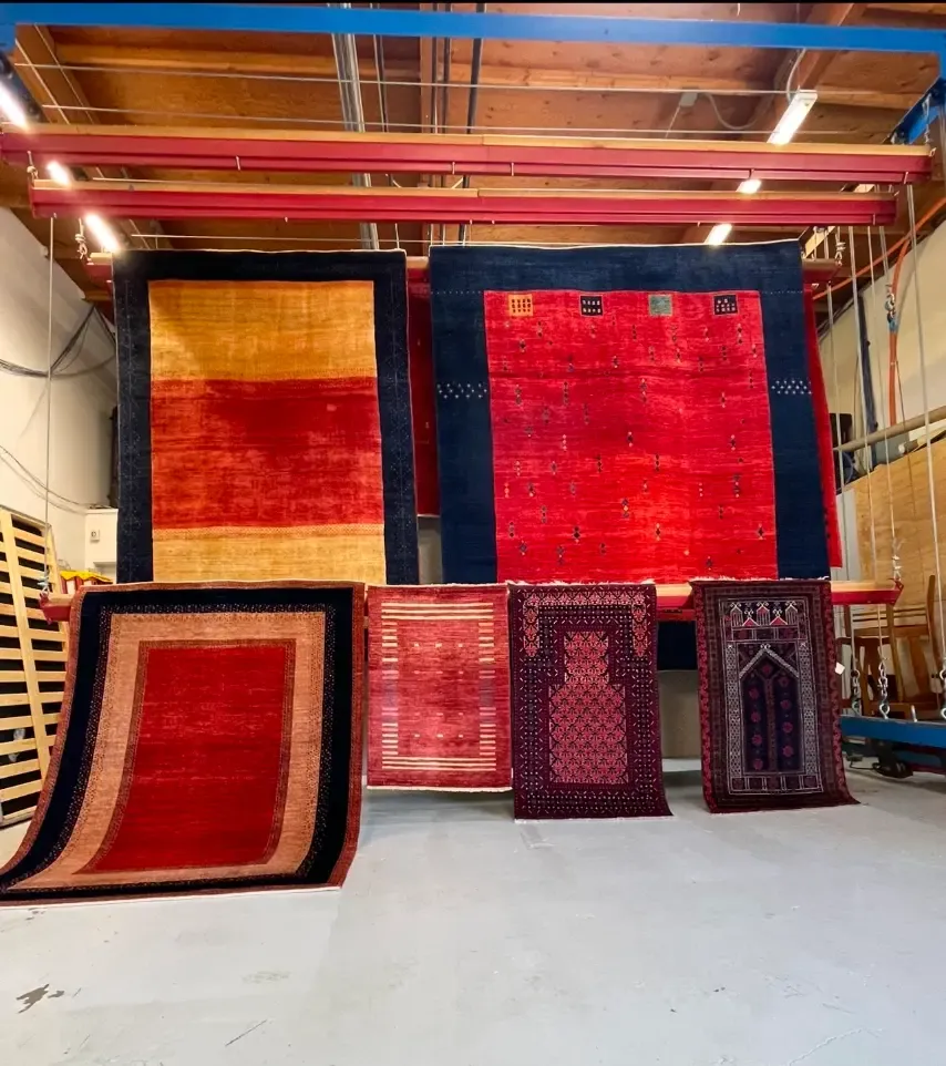 Wool and Oriental rugs hanging on racks inside the Simply Clean Care warehouse